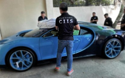 SEARCH ENDS. Customs authorities inspect the smuggled blue Bugatti Chiron sports car in Muntinlupa City on Wednesday (Feb. 21, 2024). The vehicle is the second of the two Bugatti Chiron sports cars that were the subject of a search earlier launched by the agency. 