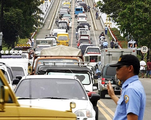 (FILES) A traffic aide directs traffic near a bridge leading to the central city of Cebu, 9 January 2007. 