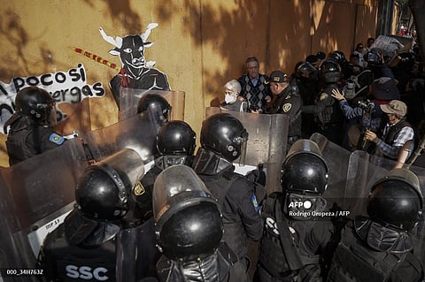 (FILE PHOTO) An attendee (one in center) is shielded from protesters by the riot police at the gate of the Monumental Plaza de Toros Mexico during a protest against bullfights in Mexico City, on 28 January 2024. Activists protested on Sunday against a resumption of bullfighting in Mexico City, after the Supreme Court revoked an earlier suspension.
