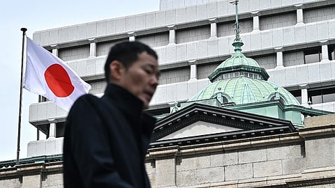 A man walks past the Bank of Japan (BoJ) headquarters complex in central Tokyo on 19 March 2024. 