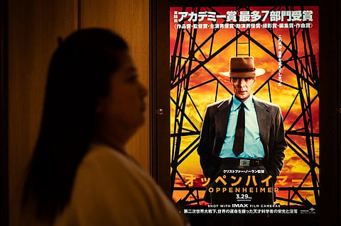 A woman walks past a poster for the film 'Oppenheimer' in Tokyo on 29 March 2024. Oscars best picture winner "Oppenheimer" was finally released on 29 March in Japan, where its subject — the man who masterminded the atomic bomb — is a highly sensitive and emotional topic.

