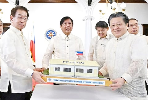 PRESIDENT Ferdinand Marcos Jr. receives a model barrio school from FFCCCII president Dr. Cecilio Pedro (right) and executive vice president Victor Lim during the induction of officers of the charity organization in Malacañang Palace in June.
