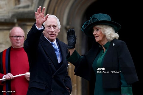 Britain's King Charles III (C) and Britain's Queen Camilla (R) waves as they arrive at St. George's Chapel, Windsor Castle, to attend the Easter Mattins Service, on 31 March 2024.
