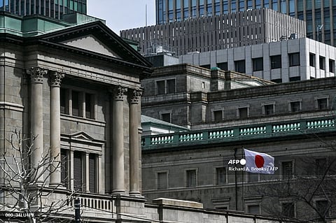 The Japanese flag flies over part of the Bank of Japan (BoJ) headquarters complex in central Tokyo on 19 March 2024. 
