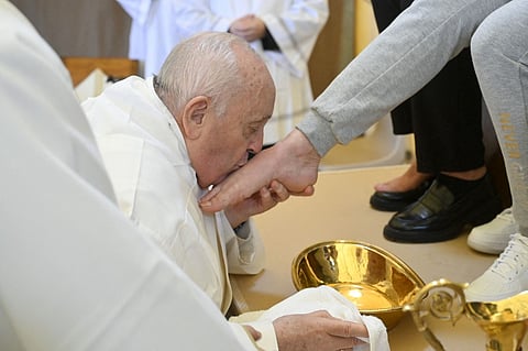 This photo taken and handout on March 28, 2024 by The Vatican Media shows Pope Francis performing the "Washing of the Feet" of inmates during a private visit at the Rebibbia prison for women in Rome as part of Holy Thursday.
