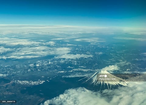 This aerial view of Mount Fuji, Japan's highest peak at 3,776 meters (12,388 feet), is seen from the window of a flight from Tokyo to Hong Kong, above Shizuoka Prefecture on 1 March 2024.