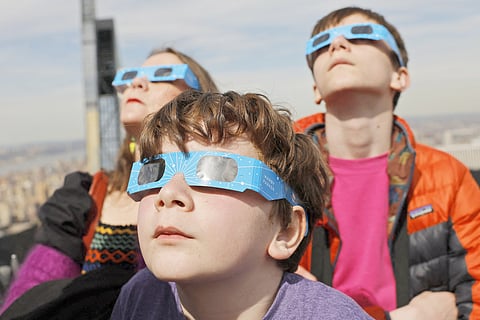 PEOPLE watch a partial solar eclipse from the Top of the Rock at Rockefeller Center in New York City. The city isn’t in the path of totality, with only 90 percent of the sun covered by the moon visible. 