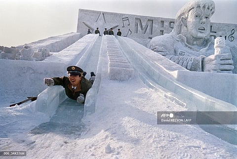 A member of the Japan Self-Defense Forces tests long slides made of blocks of ice right next to a gigantic snow sculpture of American rock star Michael Jackson in a park in Sapporo, 5 February 1988 before the opening of the 39th Sapporo Snow Festival. 

These sculptures are located at the Makomanai festival site, installed at the Ground Self-Defense Forces military base. 

Soldiers of the Self-Defense Forces help build the snow sculptures. 

134 snow sculptures were displayed around the city during the week-long festival, which has taken place annually since 1950. 

It is one of the largest winter events in Japan, bringing together around 2 million visitors each year.

