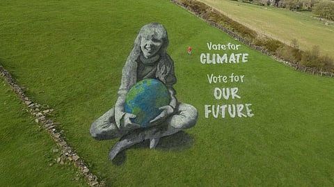 50-meter field painting of a girl holding the Earth