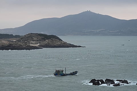 A fishing boat returns to port at dawn at the north end of Pingtan Island, the closest point in China to Taiwan’s main island, in China's southeast Fujian province on January 16, 2024.

