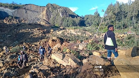 People gather at the site of a landslide in Maip Mulitaka in Papua New Guinea's Enga Province on 24 May 2024. 