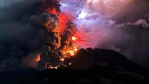 Mount Ruang spewing hot lava and smoke against a backdrop of lightning bolts overnight 