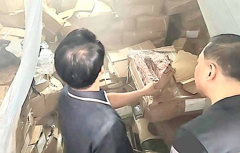 PERSONNEL of the Bureau of Customs and the Department of Agriculture inspect the P100 million worth of agricultural products seized from an unregisted cold storage facility in Kawit, Cavite recently. 
