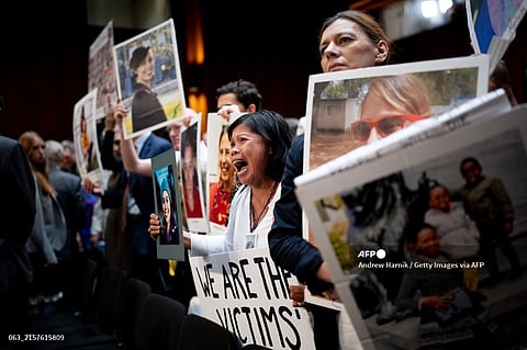 Clariss Moore of Toronto, Canada, holds a photograph of her daughter Danielle Moore and stands with other family members of those killed in the Ethiopian Airlines Flight 302 and Lion Air Flight 610 as she becomes emotional while screaming at Boeing CEO Dave Calhoun as he departs following a Senate Homeland Security and Governmental Affairs Investigations Subcommittee hearing on Boeing's broken safety culture on Capitol Hill on June 18, 2024 in Washington, DC. 