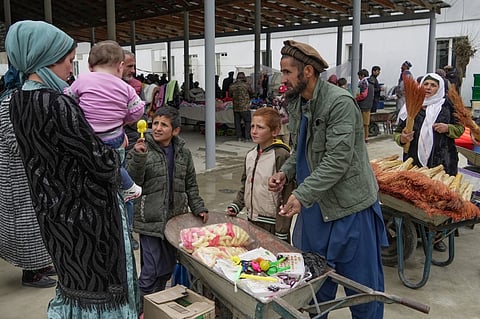 Tajiks and Afghans sell and buy food and household goods at a bazaar in the Tajik town of Kalaikhum on the border with Afghanistan. For Afghans living under Taliban rule, a Saturday market is a rare chance to cross the border into neighboring Tajikistan and pick up food and household goods.
