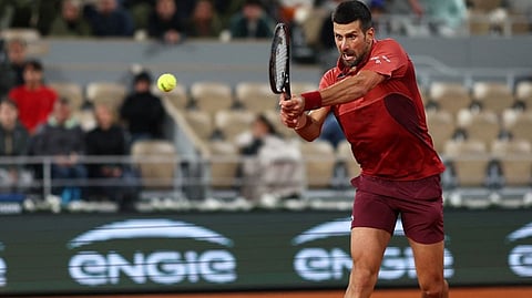 Serbia’s Novak Djokovic plays a backhand return to Italy’s Lorenzo Musetti during their men’s singles match on Court Philippe-Chatrier on day seven of the French Open tennis tournament at the Roland Garros Complex in Paris on Sunday