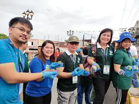DENR regional executive director Ralph Pablo (center) with Marbie Kaneko (2nd from left), assistant mall manager of SM City Balanga in Bataan, and other volunteers prepare to throw bokashi balls into the Ibayo River.