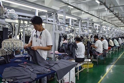 This photo taken on June 27, 2024 shows employees working on sun protection clothing at a factory in Fuyang, in eastern China's Anhui province.

