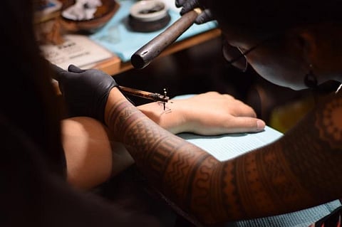 Gaspili demonstrates ‘pambabatok’, a traditional process of tattooing that involves tapping of the stick and bamboo to embed the ink on the skin.