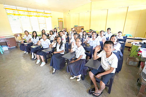 Labo Elementary School students with recycled chairs from traded-in Samsonite luggage pieces.