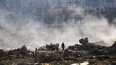 A Palestinian man salvages items from a waste dump atop building rubble at al-Bureij camp in the central Gaza Strip on June 2, 2024, amid the ongoing conflict between Israel and the Palestinian Hamas militant group.
