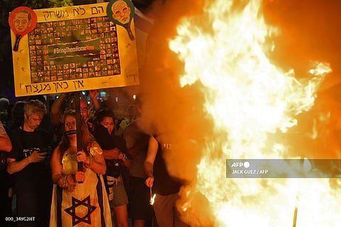 Relatives and supporters of Israelis taken hostage by Palestinian militants in Gaza stand around a fire as they demonstrate calling for their release in the Israeli coastal city of Tel Aviv.
