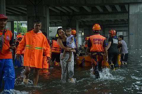 Residents are rescued from their flooded homes in Barangay Tatalon, Quezon City as the southwest monsoon is intensified by Typhoon Carina.