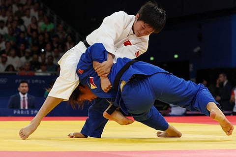 KIYOMI Watanabe (blue) gets dominated by Tang Jing of China during their women’s -63-kilogram judo competition of the Paris Olympics on Tuesday at the Champ-de-Mars Arena in the French capital.