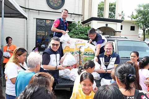 Members of the  Rotary Club of Makati Disaster Relief Team, led by RC Makati president Keith Harrison (right, wearing eyeglasses), along with Rotarians CB Rivilla (left, in sunglasses), RC Makati chief of staff Ron Dotaro (standing, at the back of the truck bearing relief goods) and RC Makati VP Chris Ferareza (at the back of president Harrison) giving relief goods to members of the  community in Montalban, Rizal affected by the flood brought on by super typhoon ‘Carina.’
