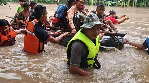 RESCUERS pull a family to safety after heavy rains caused flooding in Barangay Timbangan in Shariff Aguak, Maguindanao. 