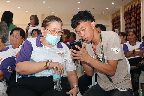 VOLUNTEER gives pointers to a senior citizen during the IDEATe event in Carcar City, Cebu.