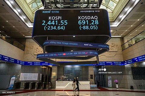 Great recession threatens People walk under a monitor displaying the benchmark Kospi index and the Korean Securities Dealers Automated Quotations (KOSDAQ) after the close of trading in Seoul. Stocks plunged in most markets after weak US jobs data fanned fears of a recession in the world’s top economy and boosted bets on several Federal Reserve interest rate cuts.