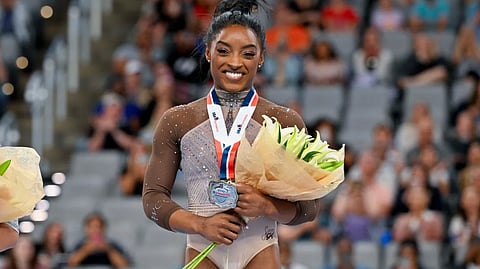 Simone Biles poses for a photo with her gold medal and commemorative belt buckle after finishing first in the women’s 2024 Xfinity U.S. Gymnastics Championships at Dickies Arena on 2 June 2024 in Fort Worth, Texas.
