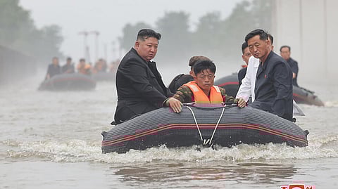 An undated photo released by North Korea's official Korean Central News Agency shows leader Kim Jong Un (left) in a dinghy as he inspects a floot-hit part of Sinuiju