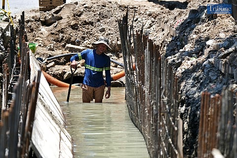 LOOK: Construction workers are wading through the water while working on the Department of Public Works and Highways' flood control project along Santa Mesa in Manila on Sunday, 4 August 2024. 