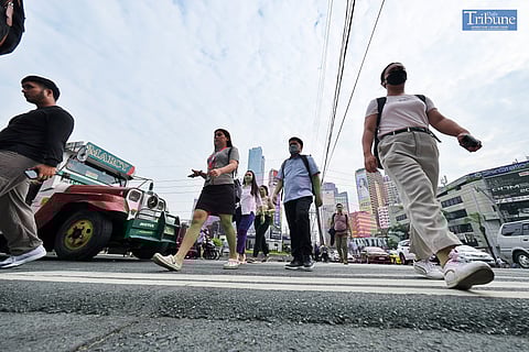 Pedestrians cross a major thoroughfare in Makati City on Tuesday. 