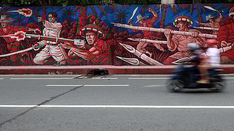 LOOK: Pedestrians and motorists pass by a mural depicting the 'himagsikan' led by heroes Andres Bonifacio and Gregorio del Pilar in San Juan City on Sunday, 25 August 2024, a day before the country celebrates National Heroes Day.