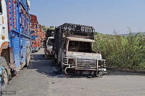 Charred vehicles still billow smoke at the shooting site on the national highway in Musakhail district, Balochistan province. Separatist gunmen shot and killed at least 22 people in southwest Pakistan on 26 August in an attack that singled out ethnic Punjabis, government officials said.
