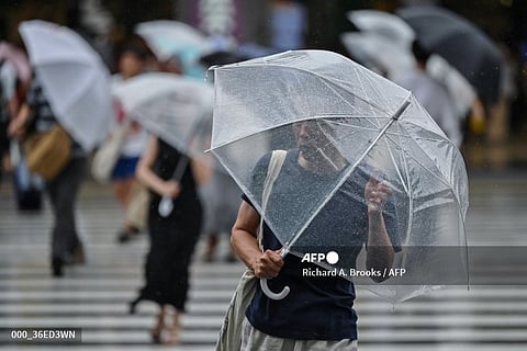 A man uses his umbrella to shelter from the wind and rain outside Shinjuku Station in central Tokyo on 16 August, 2024, as Typhoon Ampil approaches the Japanese capital. The "very strong" typhoon buffeted Japan's Pacific coast with fierce winds and heavy rain on 16 August, forcing the cancellation of hundreds of flights and trains in the Tokyo area and leaving over 2,000 homes without power.
