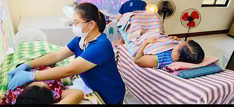 MUNICIPAL health worker checks the breast of a patient for signs of cancer.  