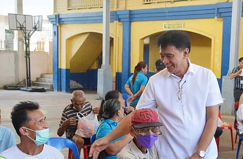 Dr. Arturo Cunanan Jr., Culion Sanitarium and General Hospital chief, greets senior citizens who are waiting at the hospital vicinity.