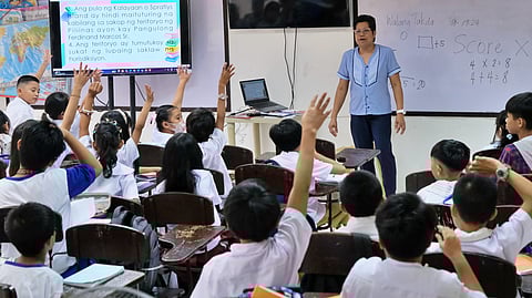 TEACHER Cristina Ambrocio with her Grade 4 pupils at the Aurora A. Quezon Elementary School in Manila. [FILE PHOTO]