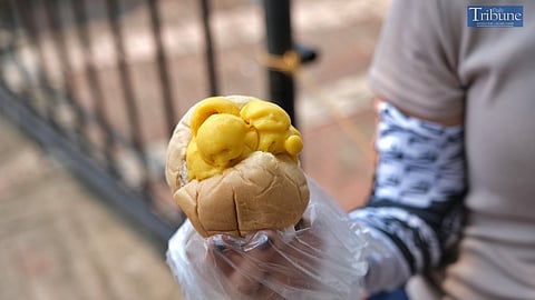 A woman tries bread with ice cream after buying it from an ambulant vendor for P30 in Manila on Thursday, 3 October 2024.