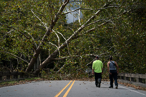 COMMUNITY volunteers Will Stone (left) and Candace Ramey walk on a damaged bridge near downed trees in Black Mountain, North Carolina, after the passage of hurricane ‘Helene.’
