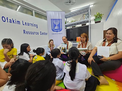 ISRAEL Ambassador Ilan Fluss (3rd from right, back) reads the story on ‘David and Goliath’ to schoolchildren at the Ofakim Learning Resource Center in Quezon City. 