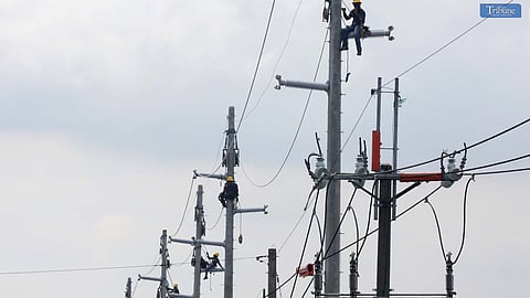 Meralco Industrial Engineering Services Corporation (MIESCOR) workers replaced an electrical wire at the newly installed pole on Commonwealth Avenue, Brgy. Holy Spirit, Quezon City. This month, Manila Electric Company (Meralco) reduced electricity rates by P0.3587 per kWh due to lower generation costs. Photo by ANALY LABOR
