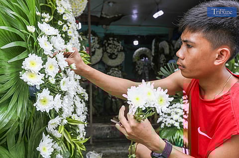 A florist carefully arranges flowers at Dangwa Flower Market in Sampaloc, Manila, on Monday, 21 October 2024, in preparation for the upcoming All Saints’ Day and All Souls’ Day.