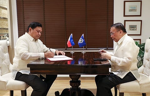 Newly-appointed Bases Conversion and Development Authority (BCDA) Chairman Atty. Hilario Paredes signs a document in front of Executive Secretary Lucas Bersamin
