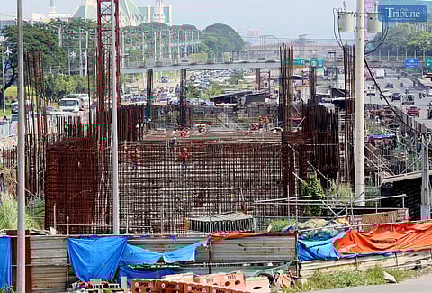 Workers continue construction on the Metro Rail Transit (MRT-7) near Techno Hub along Commonwealth Avenue in Quezon City.