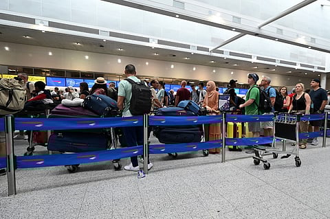 (FILES) Passengers queue in the British Airways check-in area of Gatwick Airport as some flights are cancelled or delayed, in Horley, south of London on July 20, 2024. The British government said on Friday that it had activated its civil contingencies committee to handle the response to a global IT outage that hit UK transport and health services. Airports including London Luton, Belfast and Edinburgh warned of longer waiting times for passengers because of the glitch, which was apparently caused by an update to an antivirus program.
